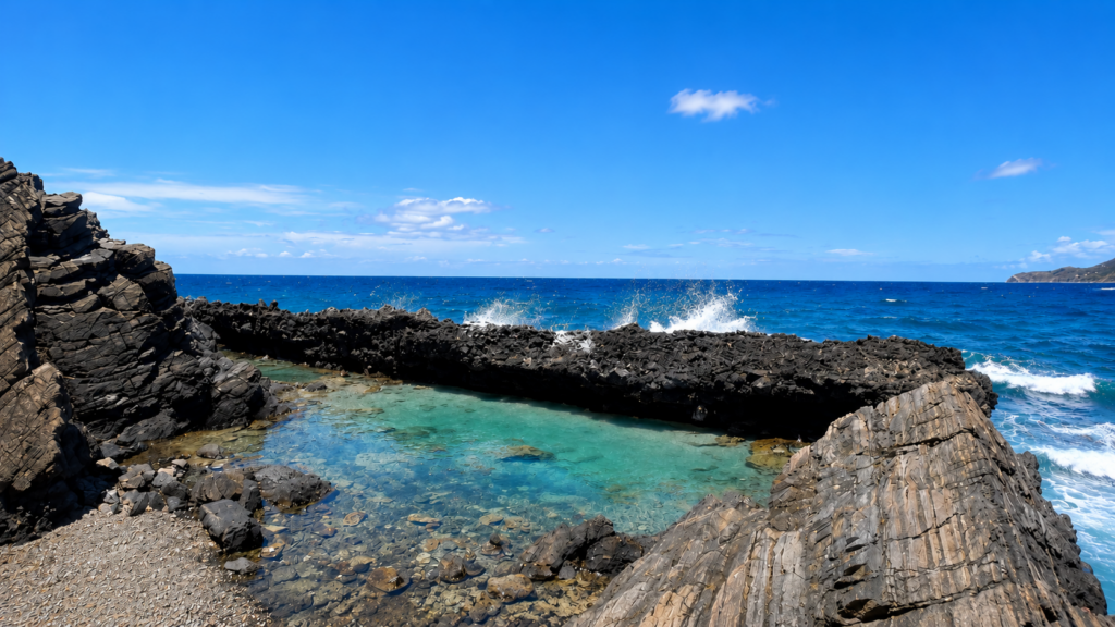 Natural tide pool on St. Croix surrounded by dramatic volcanic rock formations, with crystal-clear turquoise water and waves crashing beyond.